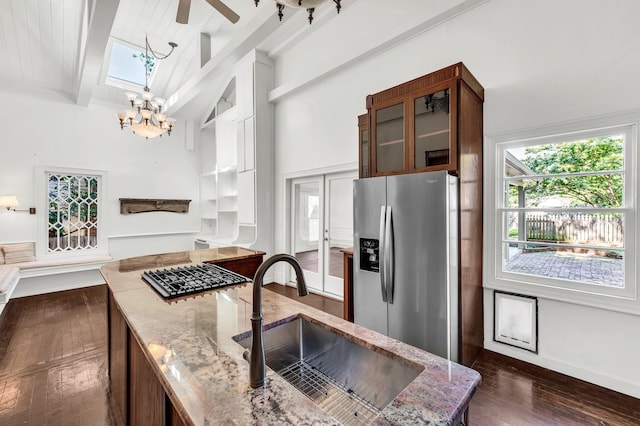 kitchen featuring a skylight, beam ceiling, sink, dark wood-type flooring, and stainless steel appliances