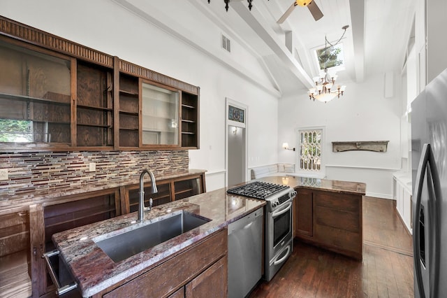 kitchen with stainless steel appliances, light stone countertops, high vaulted ceiling, and sink