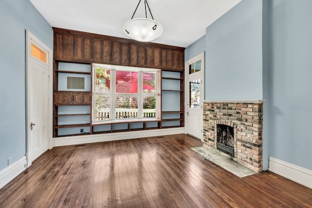 unfurnished living room featuring a fireplace and dark hardwood / wood-style floors