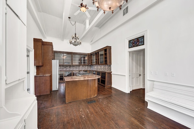 kitchen with beamed ceiling, a center island, dark hardwood / wood-style flooring, white fridge, and decorative light fixtures