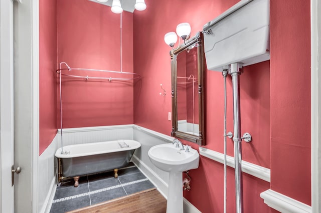 bathroom with a bathing tub and hardwood / wood-style floors