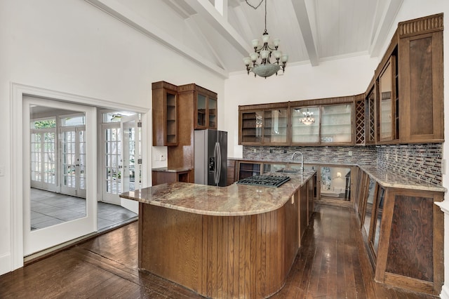 kitchen featuring light stone counters, tasteful backsplash, dark wood-type flooring, stainless steel appliances, and lofted ceiling with beams