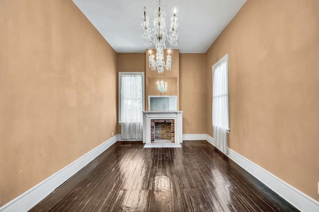 unfurnished living room with hardwood / wood-style flooring and an inviting chandelier