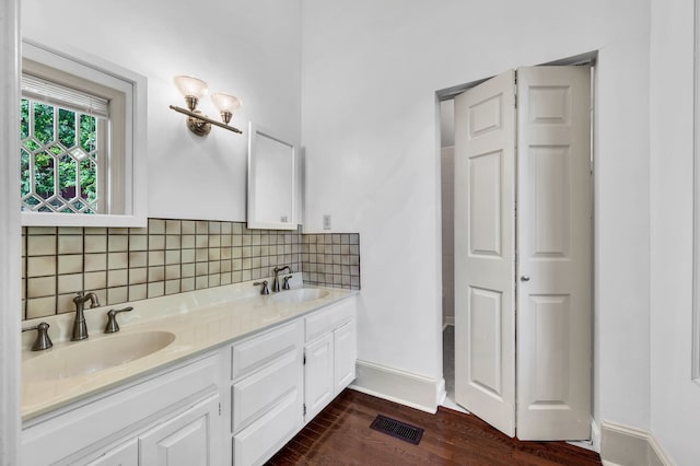 bathroom with hardwood / wood-style floors, decorative backsplash, and vanity