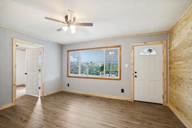 entryway with a healthy amount of sunlight, dark wood-type flooring, and wood walls