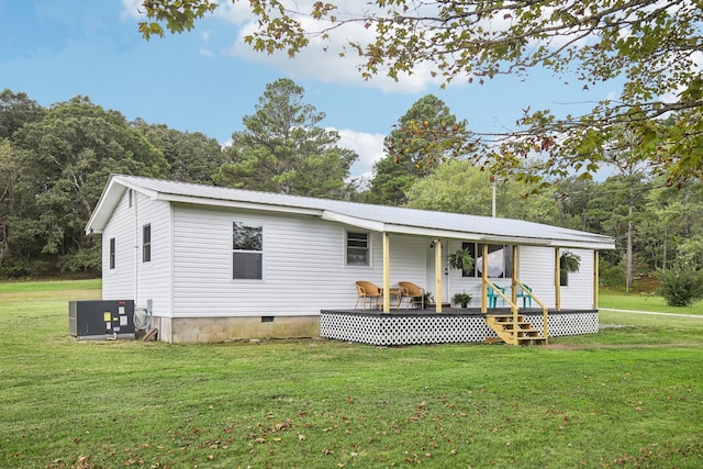 back of property with a wooden deck and a yard