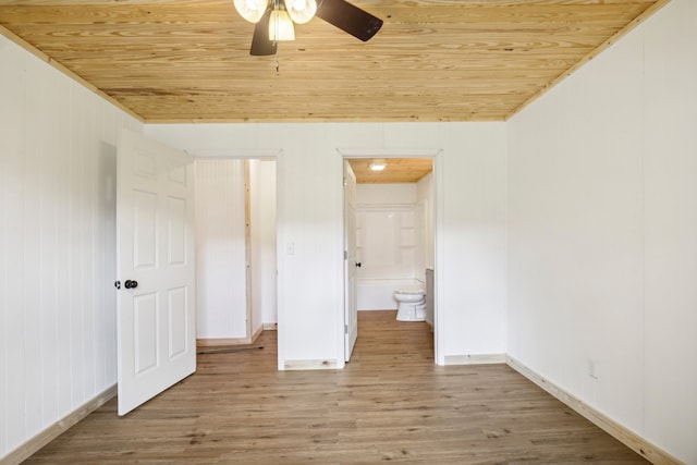 unfurnished bedroom with wood-type flooring, ensuite bath, ceiling fan, and wooden ceiling