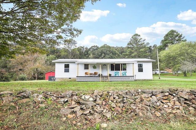 manufactured / mobile home with an outdoor structure and a front lawn