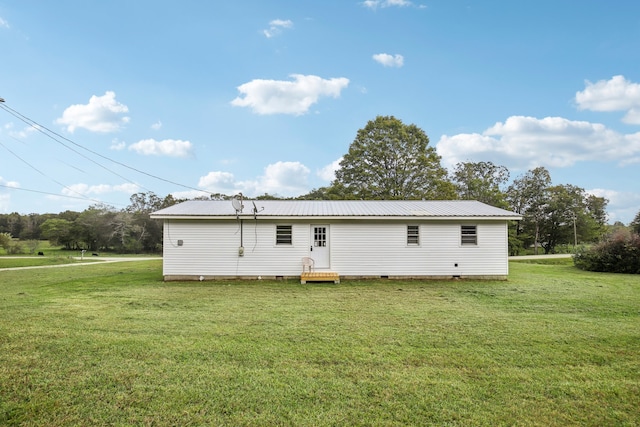 rear view of house featuring a lawn