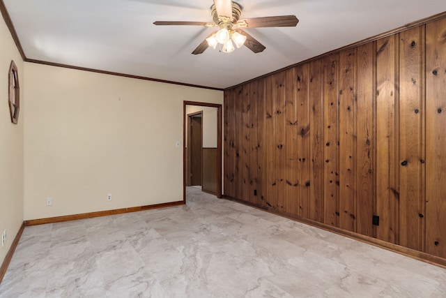 unfurnished room featuring wood walls, crown molding, and ceiling fan