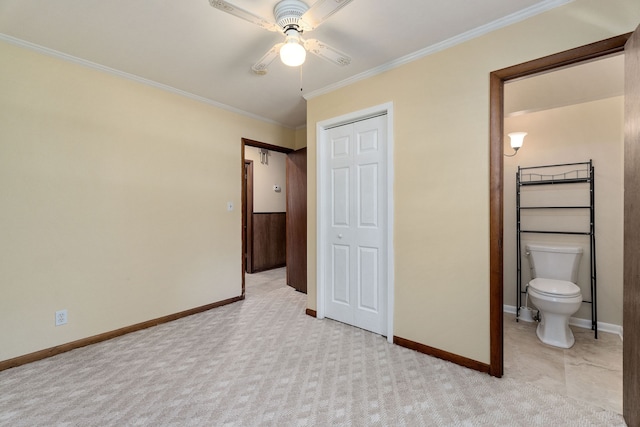 unfurnished bedroom featuring ornamental molding, light carpet, ceiling fan, and connected bathroom