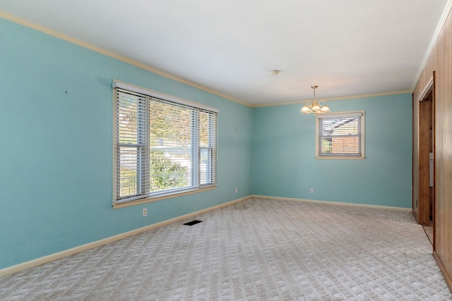 carpeted spare room with an inviting chandelier, crown molding, and a healthy amount of sunlight