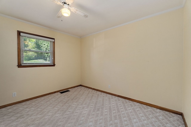 spare room featuring ceiling fan, ornamental molding, and light carpet