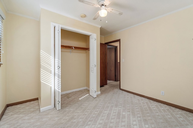 unfurnished bedroom with ceiling fan, light colored carpet, a closet, and crown molding