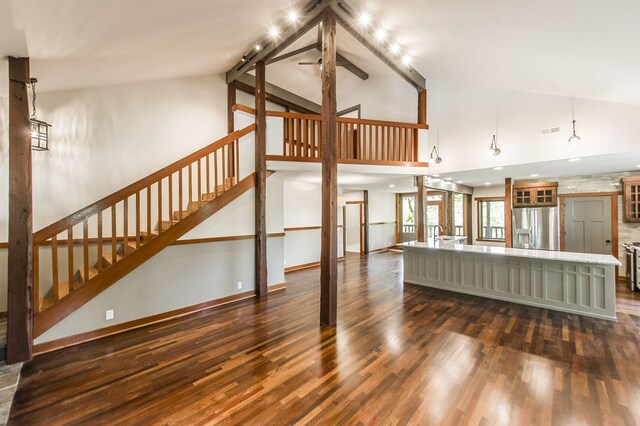 unfurnished living room with stairway, dark wood finished floors, visible vents, and high vaulted ceiling