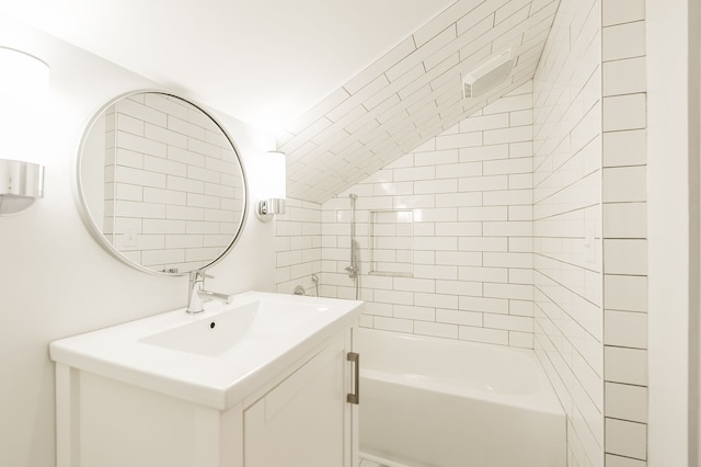 bathroom with tiled shower / bath and vanity