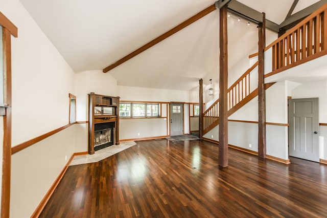 unfurnished living room featuring wood-type flooring, high vaulted ceiling, beam ceiling, and a tile fireplace