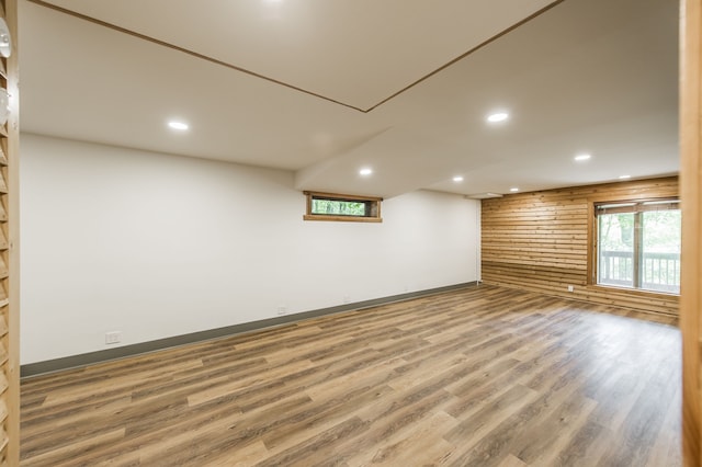 basement with wood-type flooring and wooden walls