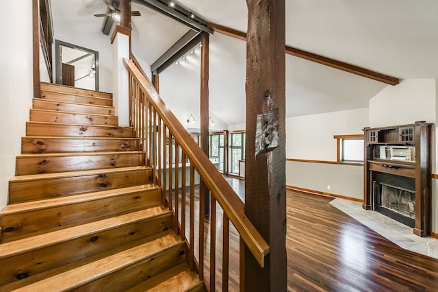 stairs featuring ceiling fan, vaulted ceiling with beams, and hardwood / wood-style floors