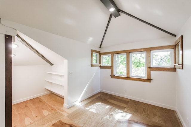 bonus room with baseboards, vaulted ceiling with beams, and wood finished floors