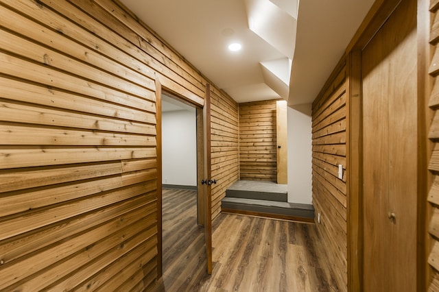 hall with wood walls and dark hardwood / wood-style flooring