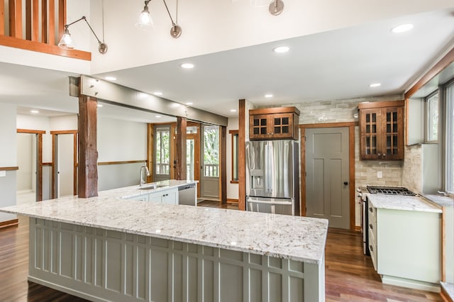 kitchen featuring hanging light fixtures, sink, gray cabinetry, stainless steel appliances, and a spacious island