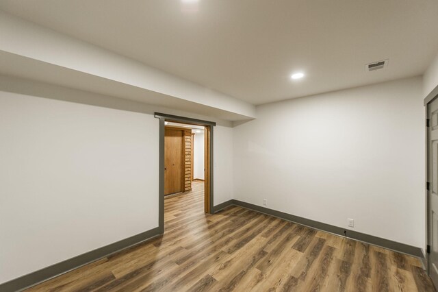 finished basement featuring visible vents, recessed lighting, baseboards, and wood finished floors