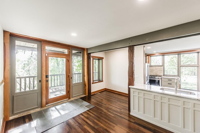 doorway to outside with visible vents, a sink, baseboards, recessed lighting, and dark wood-type flooring