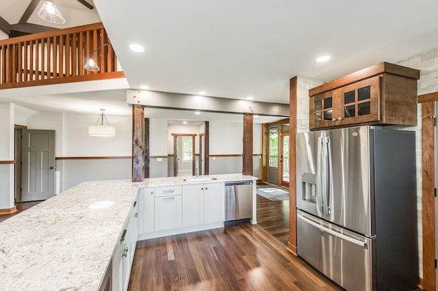 kitchen with dark wood-style flooring, light stone countertops, glass insert cabinets, stainless steel appliances, and white cabinetry