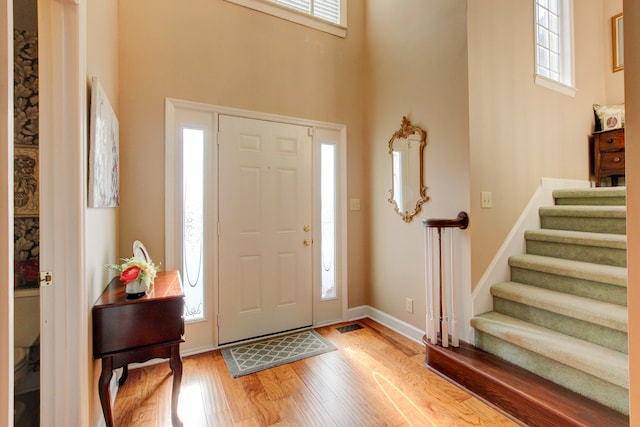 foyer entrance featuring hardwood / wood-style flooring and a high ceiling