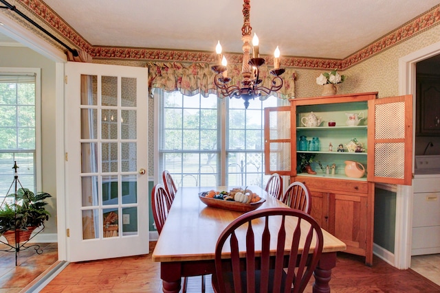 dining space featuring a notable chandelier, washer / dryer, plenty of natural light, and hardwood / wood-style floors