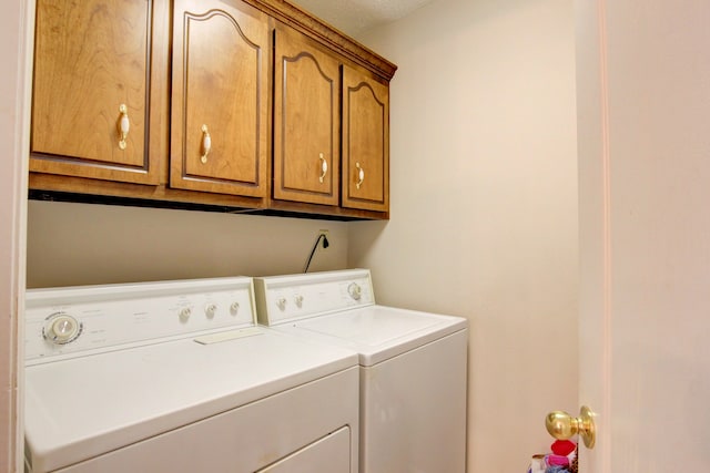 laundry room featuring separate washer and dryer and cabinets