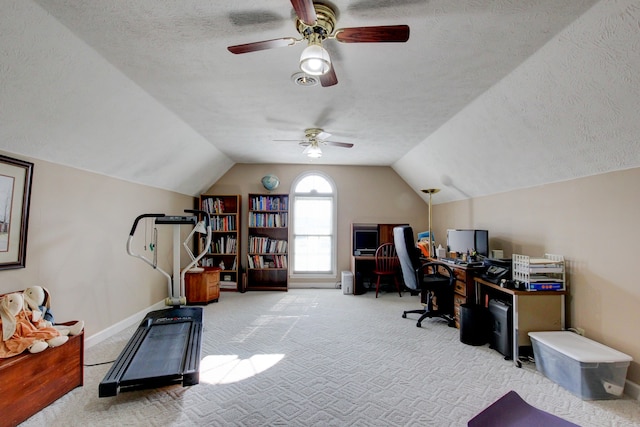 home office featuring lofted ceiling, ceiling fan, light carpet, and a textured ceiling