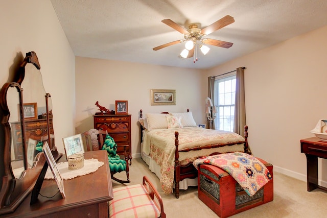 bedroom featuring a textured ceiling, ceiling fan, and light colored carpet