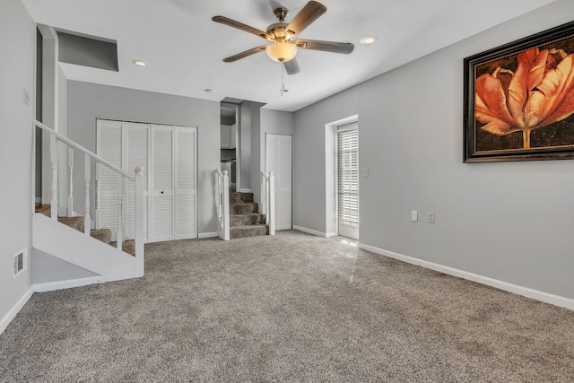 unfurnished bedroom with ceiling fan, two closets, and carpet flooring