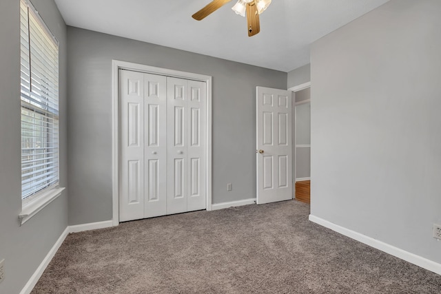 unfurnished bedroom featuring ceiling fan, a closet, and carpet