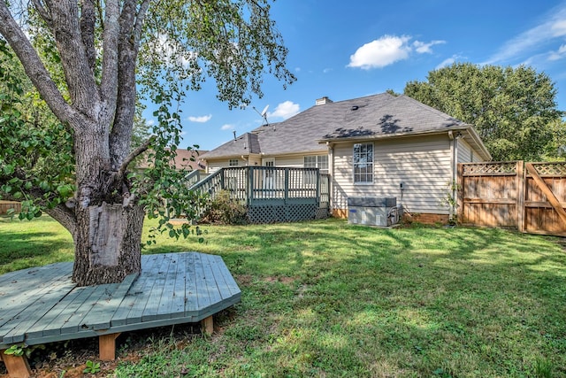 back of house featuring a lawn and a wooden deck