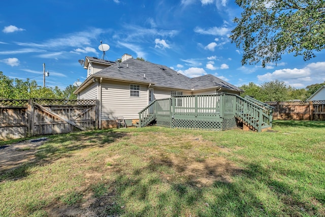 rear view of house featuring a deck and a lawn