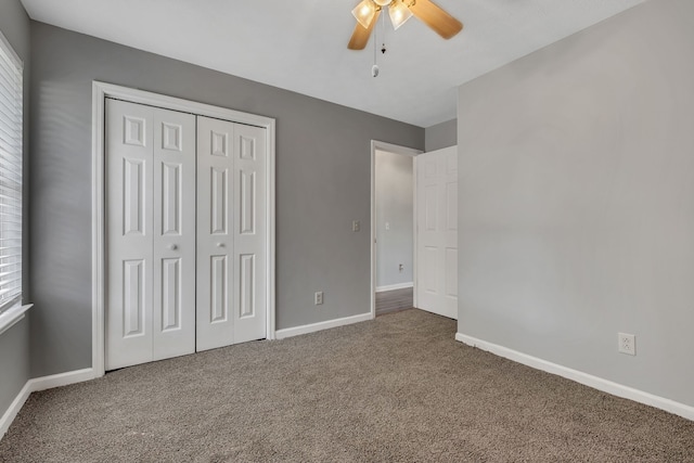 unfurnished bedroom with ceiling fan, a closet, and carpet