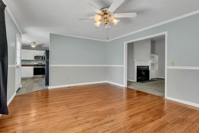 unfurnished living room with ornamental molding, ceiling fan, and light hardwood / wood-style flooring