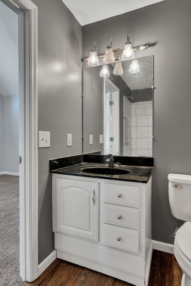 bathroom with wood-type flooring, vanity, and toilet