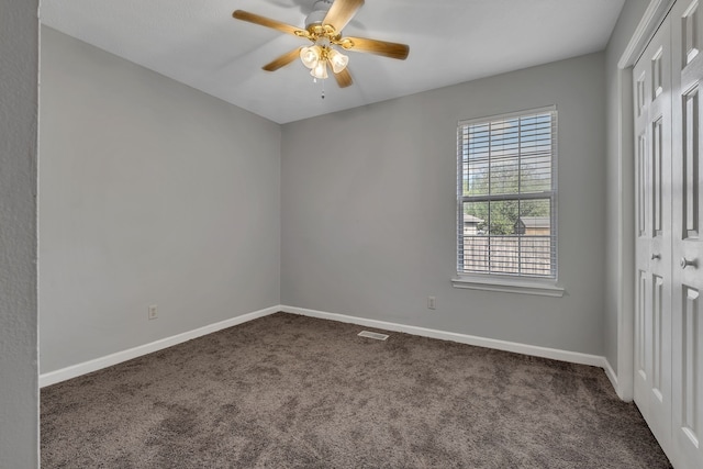 carpeted spare room with ceiling fan