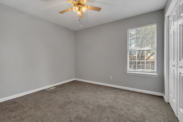 carpeted spare room featuring ceiling fan