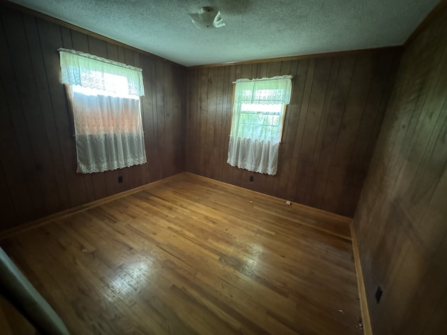 spare room featuring hardwood / wood-style flooring and wood walls