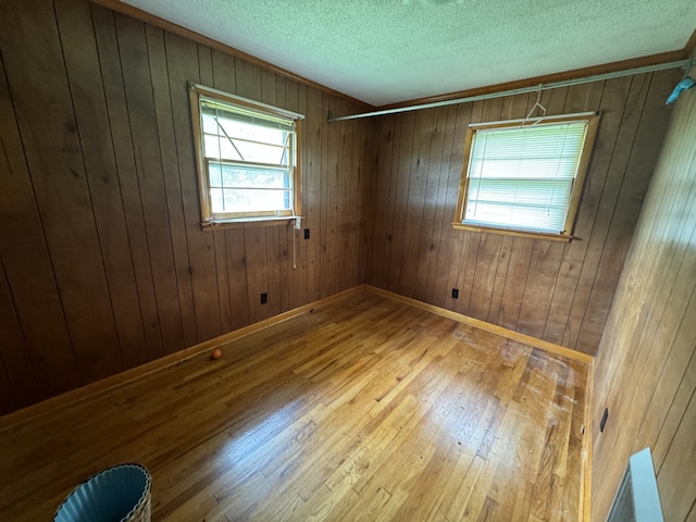 spare room featuring hardwood / wood-style flooring and wood walls