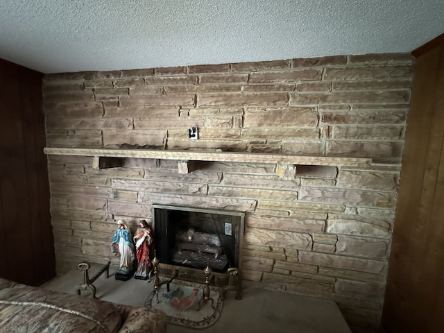 interior details featuring a stone fireplace and a textured ceiling