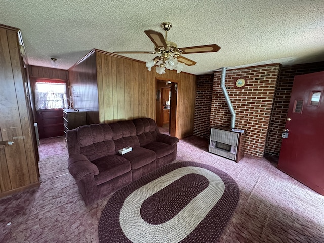 living room with wood walls, ceiling fan, brick wall, and a textured ceiling