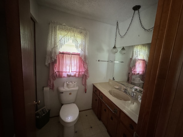 bathroom with vanity, toilet, and a textured ceiling