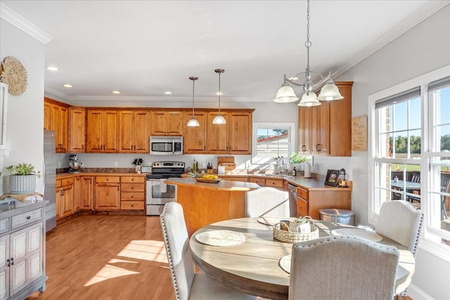 kitchen featuring an inviting chandelier, light hardwood / wood-style flooring, decorative light fixtures, stainless steel appliances, and ornamental molding