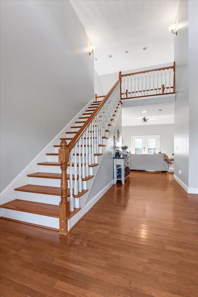 stairs featuring a high ceiling and hardwood / wood-style flooring